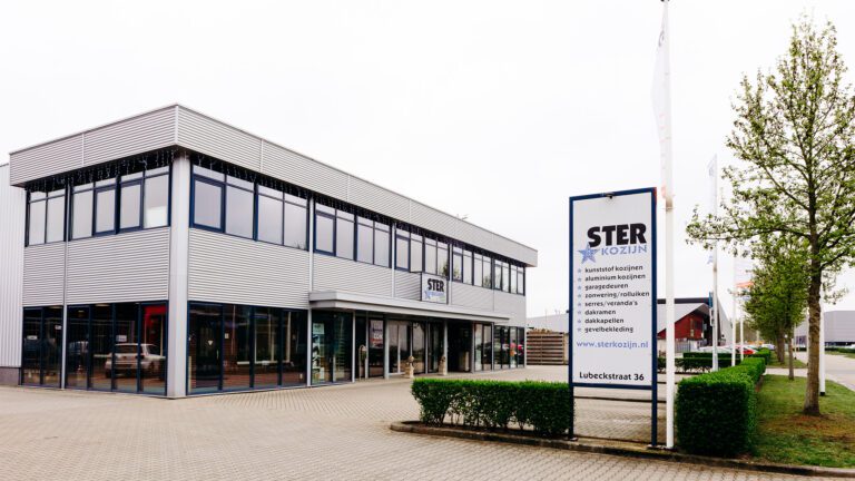 Bedrijfspand en showroom van Ster Kozijn in Oldenzaal met het bedrijfslogo en productoverzicht op het reclamebord.