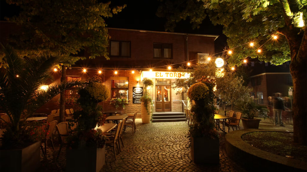 Restaurant El Toro in Kranenburg met verlicht terras en entree in de avond.